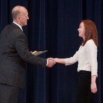 Doctor Potteiger shaking hands with an award recipient in a white shirt
